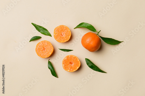 Many fresh ripe mandarin with green leaves on colored background, top view, space for text photo