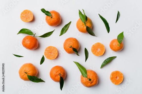Many fresh ripe mandarin as colored background  top view. Elegant background of clementines and mandarin slices Top view flat lay