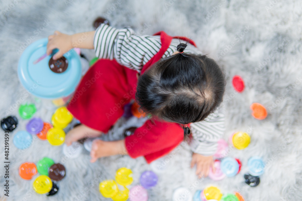 Naklejka premium Happy little girl playing with the developmental toys, Asian girl, cute kid.