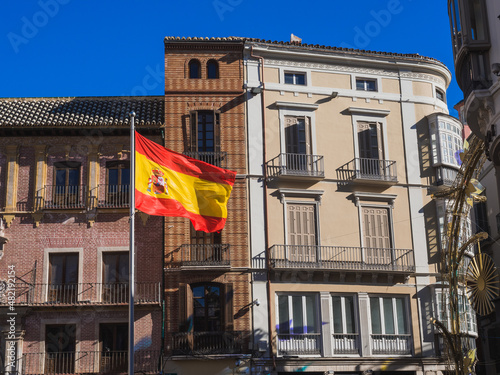 Flag of Spain fluttering in the wind in central street of Malaga  Marqu  s de Larios