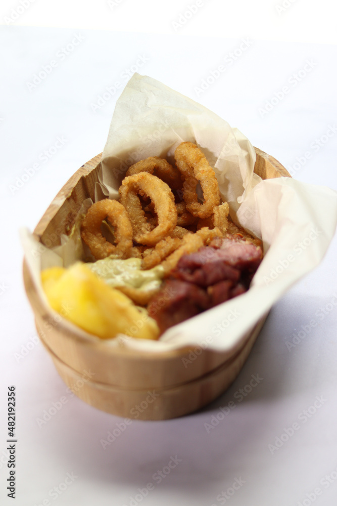 basket of pork rinds with french fries, fried yucca and onion rings