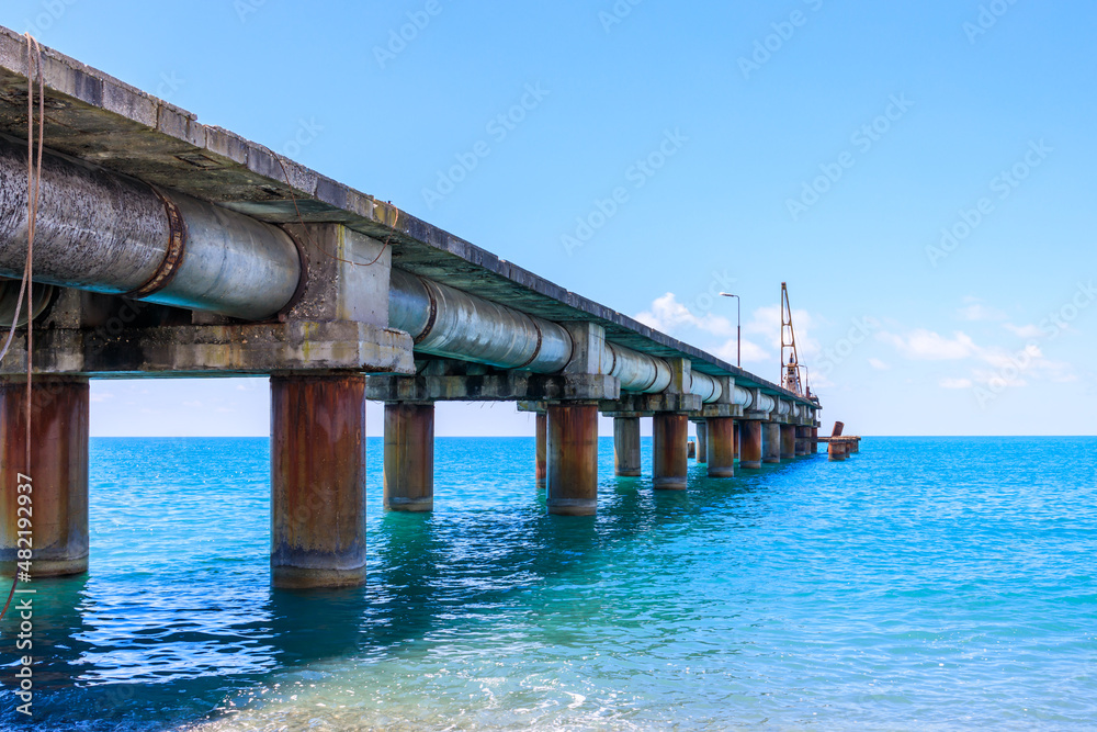 view of the sea pier going into the distance, blue sea in daylight