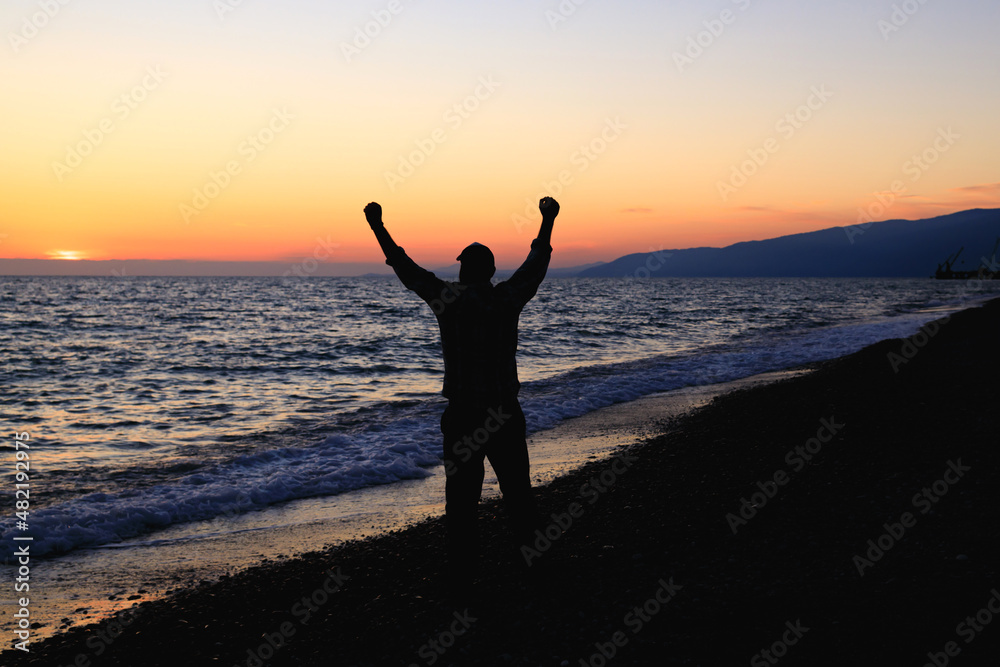 silhouette of a man on the seashore, the sea coast stretching into the distance