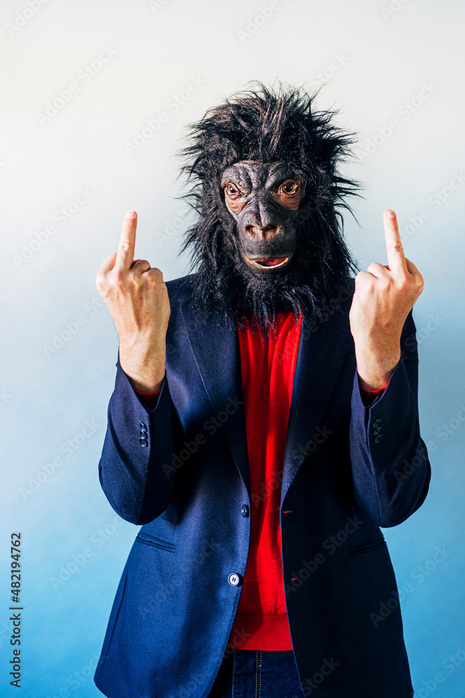 Man in suit showing middle fingers and wearing gorilla mask. Man in suit showing middle fingers and wearing gorilla mask.