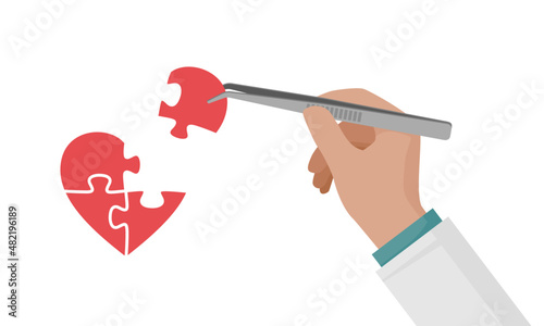 A man makes a heart puzzle with tweezers. The hand holds the puzzle piece.