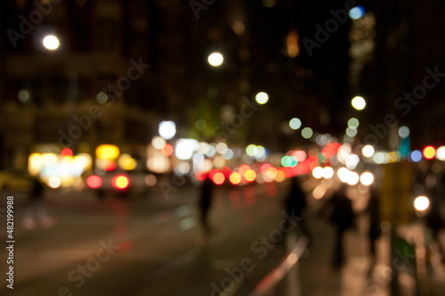 Defocused abstract background of people walking at night in busy city in Winter