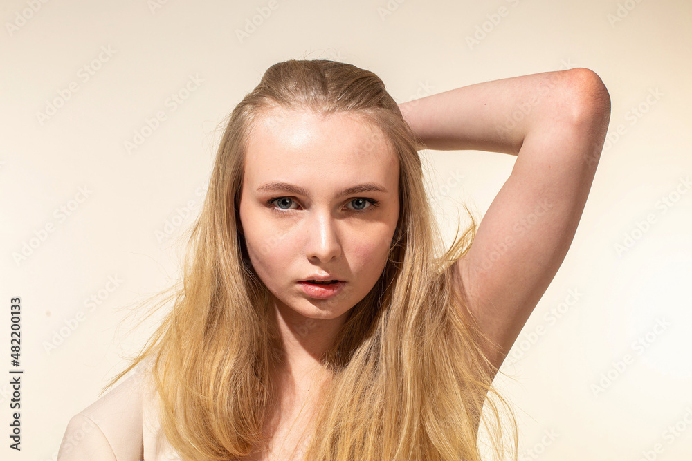 White young woman with blonde hair isolated on beige with nude make-up