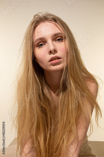 White young woman with blonde hair isolated on beige portrait