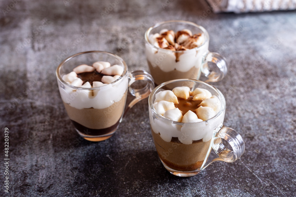Assortment of mini chocolate and nuts desserts in the glass. Mini choloate desserts on a rustic background Assortment of mini chocolate and nuts desserts in the glass. Mini choloate desserts on a rustic background
