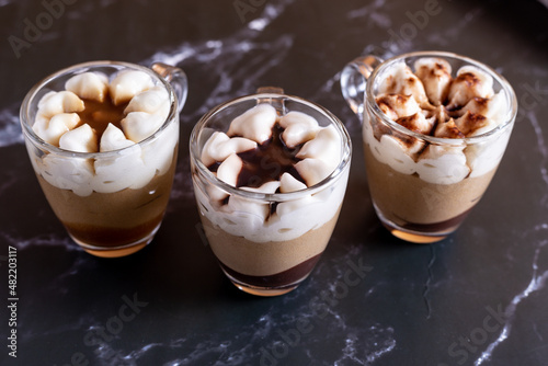 Assortment of mini chocolate and nuts desserts in the glass. Mini choloate desserts on a black background photo