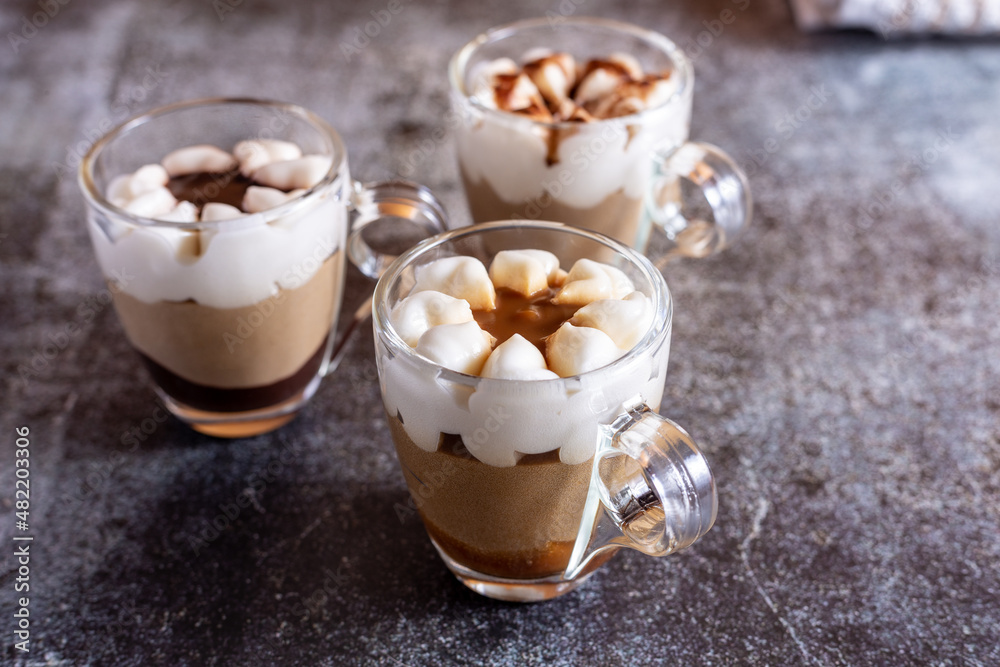 Assortment of mini chocolate and nuts desserts in the glass. Mini choloate desserts on a rustic background Assortment of mini chocolate and nuts desserts in the glass. Mini choloate desserts on a rustic background