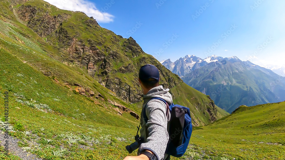 A male hiker taking a selfie with an amazing views on the mountain ridges in the Greater Caucasus Mountain Range in Georgia,Samegrelo-Upper Svaneti Region.Freedom. Wanderlust.Trekking to Koruldi Lakes