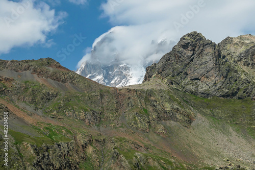 An amazing panoramic view on the mountain ridges near Mestia in the Greater Caucasus Mountain Range, Samegrelo-Upper Svaneti, Country of Georgia. The sharp peaks are covered in snow. Clouds arriving photo