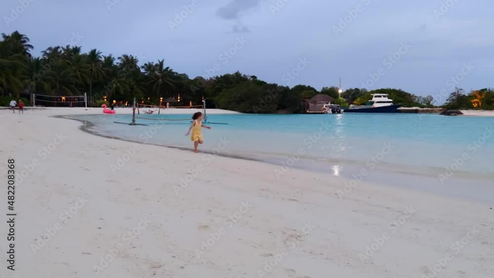 A little girl is running along the shore in the Maldives. A little girl is running along the shore in the Maldives.