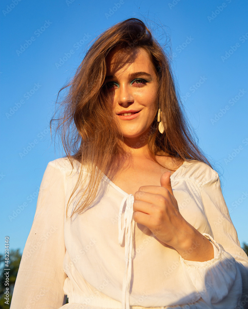 Smiling young woman with white skin with sky behind with blue eyeshadow makeup Smiling young woman with white skin with sky behind with blue eyeshadow makeup
