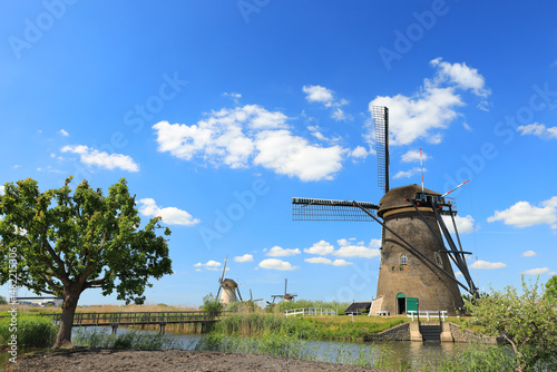 Dutch windmill on river bank, Kinderdijk, Holland