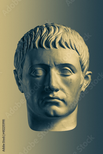 Bronze color gypsum copy of ancient statue of Germanicus Julius Caesar head for artists on brass background. Renaissance epoch. Plaster sculpture of man face. Template for art design