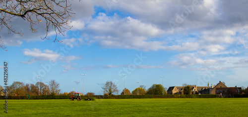 A tractor preparing the sports field in the sunlight. Canterbury