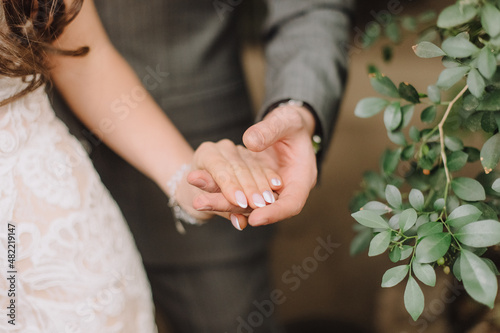 loving couple of newlyweds gently touches with hands, close-up