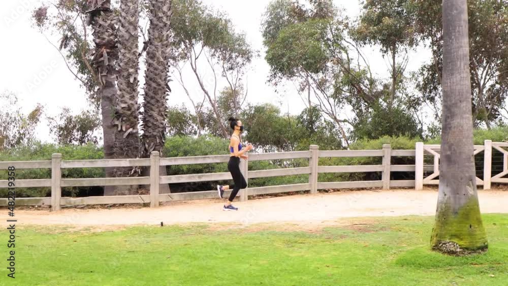 Athletic Asian woman going for her morning workout while wearing her face mask. Foggy morning in Santa Monica California. Athletic Asian woman going for her morning workout while wearing her face mask. Foggy morning in Santa Monica California.