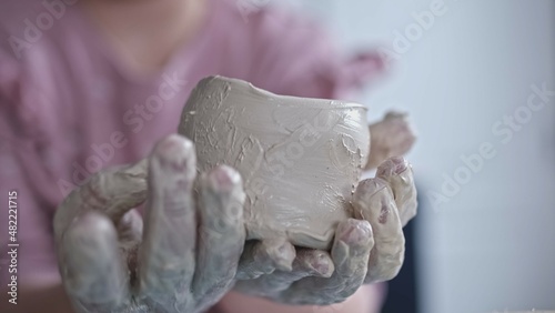Proud Young Talented Creative Caucasian Girl Holding Clay Mug Handmade Using Toy Pottery Set 