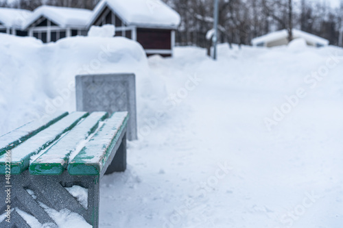 Wooden park bench and urn in winter
