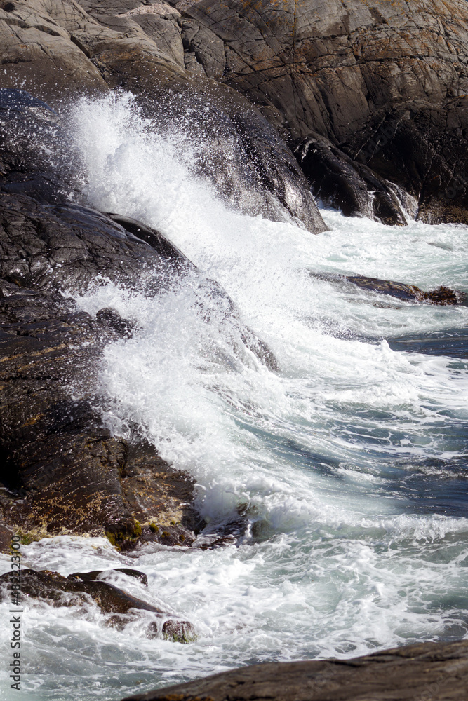 Waves crashing against the stone in the sunlight