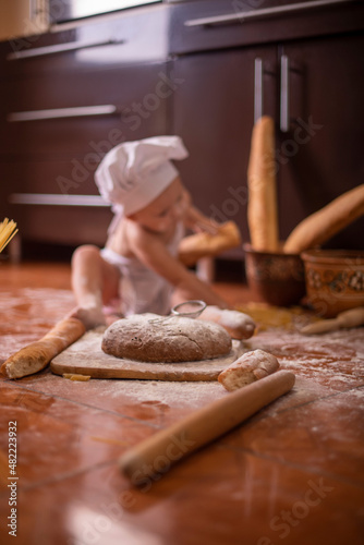  child with bread in his hands dressed as a cook