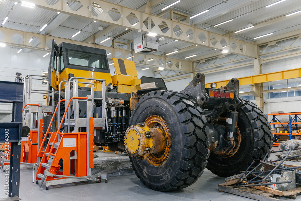 A disassembled dump truck is being repaired in the garage. A disassembled dump truck is being repaired in the garage.