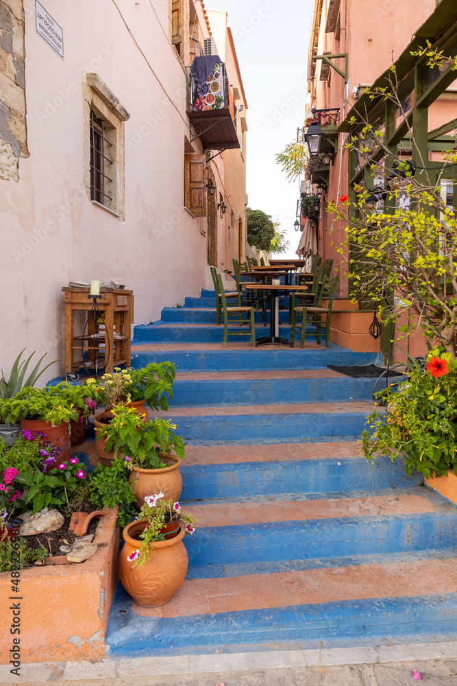 Naklejka premium Small narrow street with blue stairs in Old Town of Rethymnon, Crete island, Greece