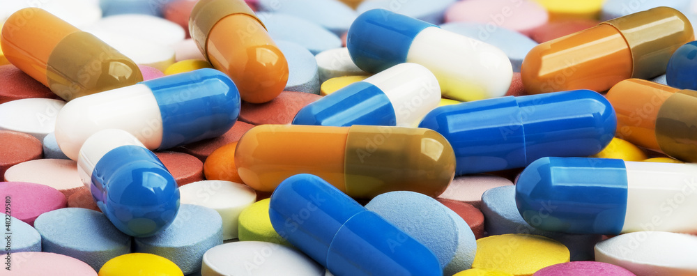Heap of medical pills in white, blue and other colors. Concept of healthcare and medicine. Heap of medical pills in white, blue and other colors. Concept of healthcare and medicine.