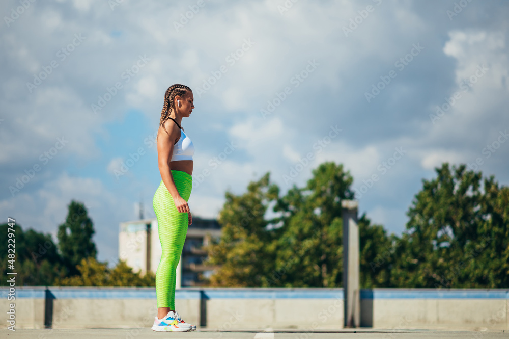 Attractive young woman running while training outside