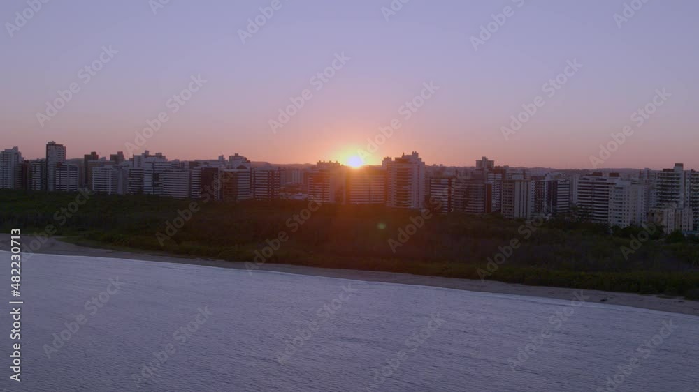 aerial view of Aracaju city in northeastern Sergipe state of Brazil with wall of buildings as the sun sets in image moving away aerial view of Aracaju city in northeastern Sergipe state of Brazil with wall of buildings as the sun sets in image moving away