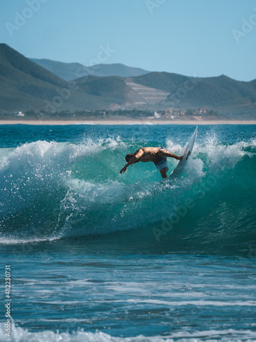 Surfer on turquoise water in Cerritos Beach, Todos Santos, Baja California 