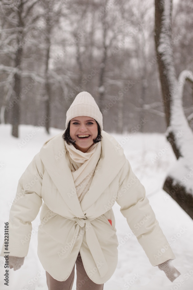 Obraz premium Two girls playing snowballs in the snow in the winter in a warm winter clothes