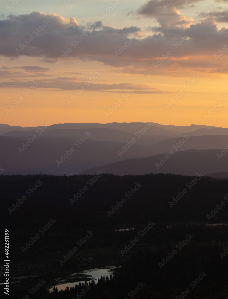 Sunlit fog making the silhouettes of the mountain ranges have different colours