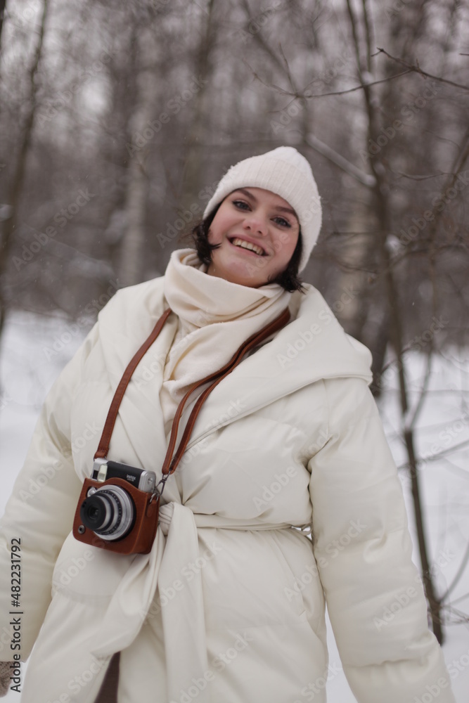 Obraz premium a girl with a camera on a winter walk in the woods