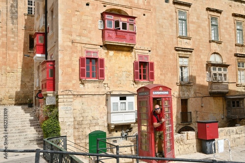 Man in traditional english red phone booth in Valletta, Malta
