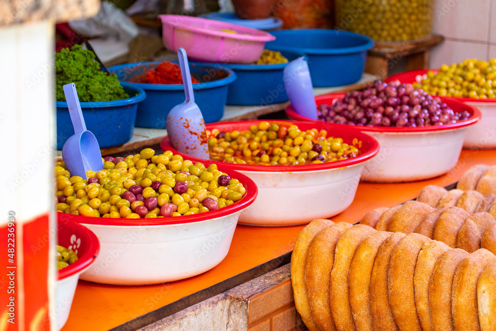 Many different types of olives and traditional round Moroccan bread (khobtz) for sale at the local markets in Moulay Idriss