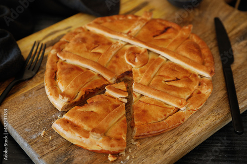 Empanada Gallega, traditional pie stuffed with tuna or meat typical of Galicia, Spain, on a wooden background. Food photography photo