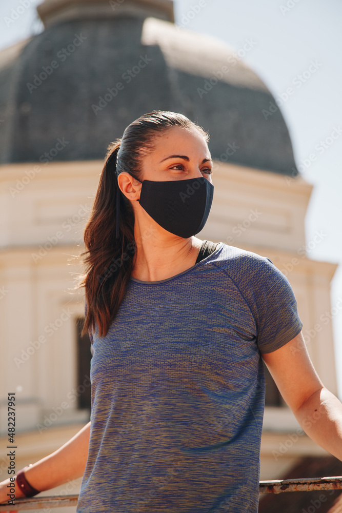Close-up shot of a young adult female looking forward standing on roof wearing face mask. Close-up shot of a young adult female looking forward standing on roof wearing face mask.