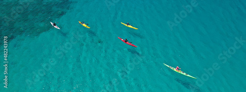 Aerial drone ultra wide panoramic photo with copy space of unidentified caucasian women paddling on tropical island exotic turquoise calm sea © aerial-drone