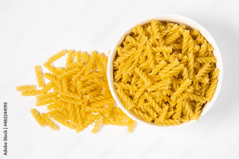 Fototapeta premium Close up of several types of dry pasta in a plate on white background