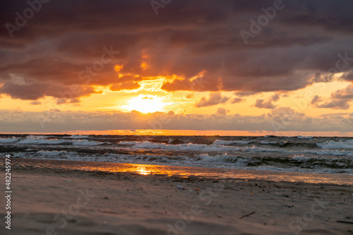 Sunset during cloudy summer day in Krynica Morska at the Baltic Sea. Beautiful view of sun behind clouds with light rays everywhere. © BridgeToHorizon