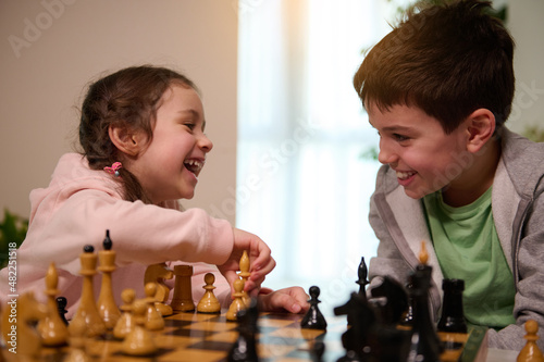 Kids having great time together playing chess. Chess game for clever mind. Logic development, leisure board games, entertainment, intelligent hobby and education concept