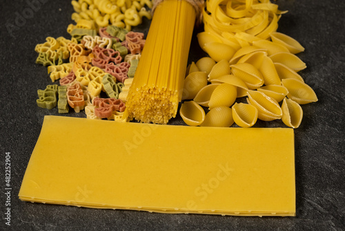 Close up of several types of dry pasta on dark background photo