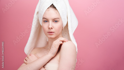 Close-up shot of young woman on pink background. 