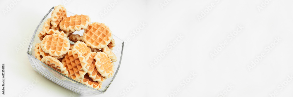 Belgian waffles in a glass bowl. holiday cookies on a white background. fresh baking concept. sweet desserts on a light texture Belgian waffles in a glass bowl. holiday cookies on a white background. fresh baking concept. sweet desserts on a light texture