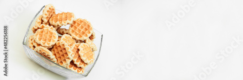 Belgian waffles in a glass bowl. holiday cookies on a white background. fresh baking concept. sweet desserts on a light texture