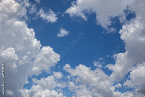 White cotton-textured clouds on a blue sky background. 